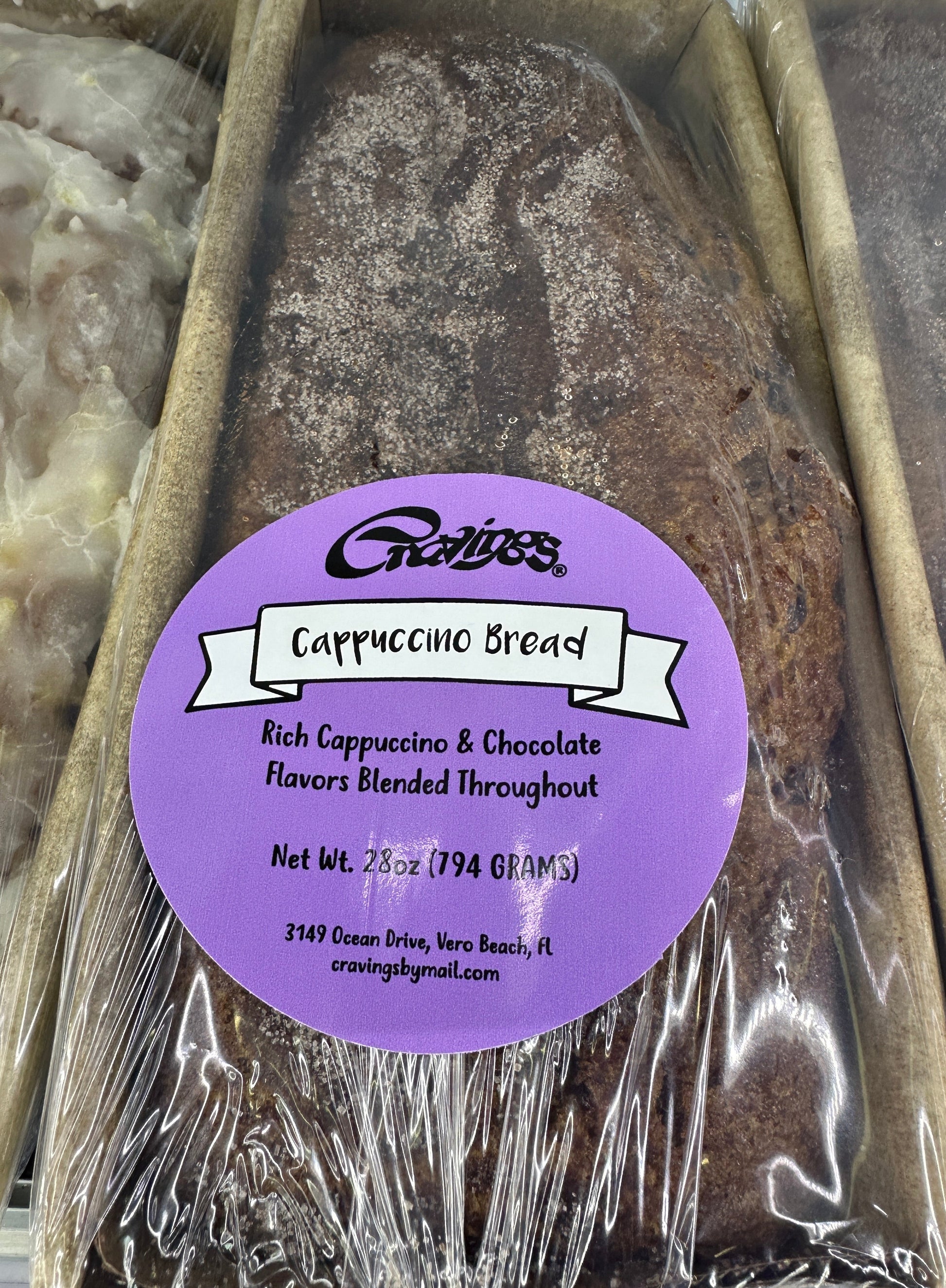 Packaged Cappuccino Bread with a purple label on a metal tray.